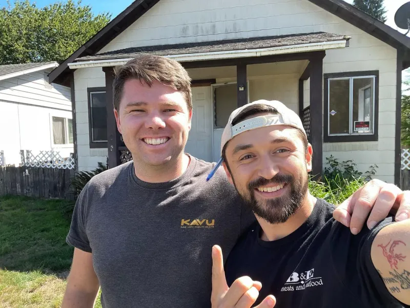 Brandon Phillips, on the right, standing in front of a Longview, WA house the company purchased